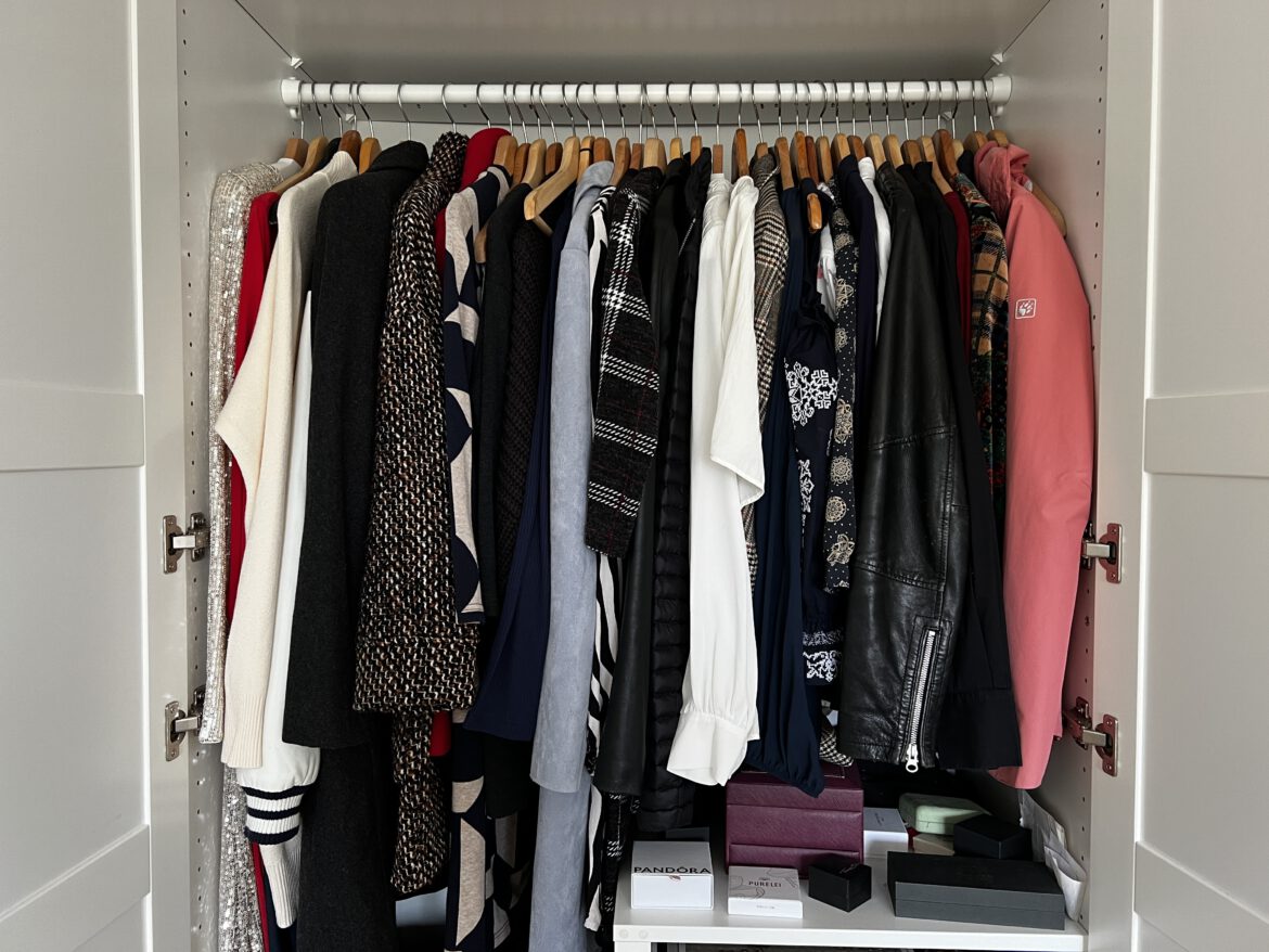 geöffneter Kleiderschrank mit Kleidungsstücken